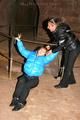 One archive girl tied and gagged by another archive girl outdoor wearing lightblue and black shiny downjackets (Pics)