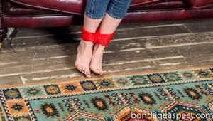 Topless and barefoot Claudia hogtied within red ropes - Photos