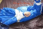 Mara tied and gagged on bed wearing s shiny blue PVC sauna suit (Pics)