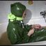 Mara wearing a sexy green shiny pvc jumpsuit with hood ties and gagges herself in a bath tub full of mud (Video)