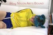 Mara tied and gagged on a white sofa wearing a sexy blue/yellow shorts and a yellow rain jacket (Pics)