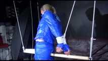 SUPERSEXY SANDRA wearing sexy shiny blue rainwear being tied and gagged overhead with ropes and a bar treated with a massager (Video)