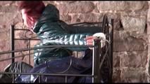 Mara tied and gagged on a princess bed in an old cellar wearing an supersexy shiny green down jacket and a rain pants (Video)