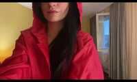 Miss Amira in a red minidress and red nylon raincoat having fun in a hotel room