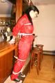 Jill tied and gagged on a pillar wearing a shiny red rainwear (Pics)