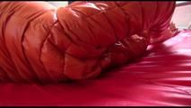 Mara tied and gagged on bed wearing a sexy orange shiny down jacket and a orange rain pants (Video)
