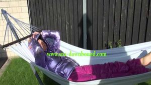 Watch Sandra enjoying her shiny nylon Downwear at a warm Summer Day in the Garden and in the Pool