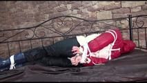 Jill tied, gagged and hooded on a princess bed in an old cellar wearing a shiny black nylon pants and a shiny red/offwhite down jacket (Video)