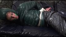 Pia tied, gagged and hooded lying on a bed with shiny nylon cloth wearing a sexy black adidas nylon pants and a green down jacket(Video)