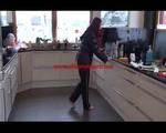 Mara wearing black rainwear tidying up the kitchen (Video)
