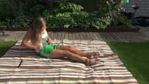 Watching sexy Sandra wearing a sexy green shiny nylon shorts and a white top taking a sun bath (Video9