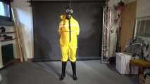 Watch Lady M bound in a yellow Rainsuit wearing a latex Hood and a Gasmask