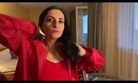 Miss Amira in a red minidress and red nylon raincoat having fun in a hotel room