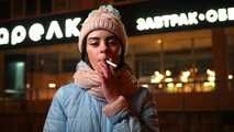 Lovely Russian girl Karina smokes a cigarette in the cold outside 