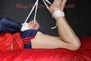Sexy Sonja wearing a blue/red shiny nylon shorts and a blue/red rain jacket being tied and gagged with ropes on the ceiling(Pics)