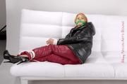 Samantha tied and gagged on a white sofa wearing a shiny red down pant and a black down jacket (Pics)