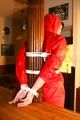 Jill tied and gagged on a pillar wearing a shiny red rainwear (Pics)