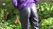 Watching sexy Sandra wearing a sexy blue rain pants and a purple rain jacket watering the flowers in the garden (Video)