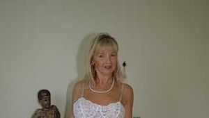 Busty blonde Marlen posing in a white negligee in the bedroom