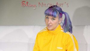 SEXY MARA lounging on the sofa wearing a sexy blue/yellow shiny nylon shorts and a yellow shiny nylon rain jacket (Pics)