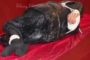 Lucy wearing a black shiny nylon rainh pants and a black down jacket tied and gagged on a sofa (Pics)