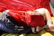 Watching sexy Jill being tied and gagged with ropes and a ballgag on a bed wearing a sexy red shiny nylon shorts and an oldschool rain jacket (Pics)