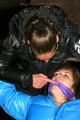 One archive girl tied and gagged by another archive girl outdoor wearing lightblue and black shiny downjackets (Pics)