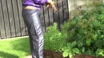 Watching sexy Sandra wearing a sexy blue rain pants and a purple rain jacket watering the flowers in the garden (Video)