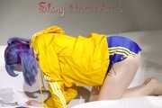 SEXY MARA lounging on the sofa wearing a sexy blue/yellow shiny nylon shorts and a yellow shiny nylon rain jacket (Pics)