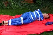 Nicole in an blue sauna suit tied and gagged in the garden (Pics)