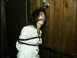 ERICA IS HANDGAGGED, BALL-GAGGED & TIED WITH BLACK ROPE TO A SOFA BED (D33-3)