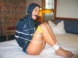 Dark-haired archive girl tied, gagged and hooded on a bed wearing a shiny nylon shorts (Pics)