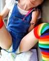 Emma with rainbow socks, a denim shortall and a pile of diapers