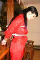 Jill tied and gagged on a pillar wearing a shiny red rainwear (Pics)