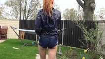 Watching our new modell RONJA wearing a sexy darkblue shiny nylon shorts and a darkblue rainjacket walking through a garden lolling in a hammock enjoying the cloth she wear (Video)