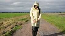 Miss Amira on the road in a transparent Schmuddelwedda raincoat, rainpants and rubber boots