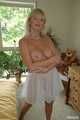 Busty blonde Marlen posing in a white negligee in the bedroom