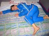 Katharina lolling on the bed wearing lightblue sexy shiny nylon rainwear (Pics)