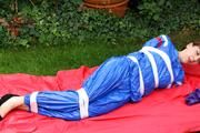 Nicole in an blue sauna suit tied and gagged in the garden (Pics)