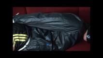 Pia tied and gagged on a sofa wearing a shiny black nylon shorts with yellow stripes and a black rain jacket (Video)