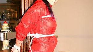 Jill tied and gagged on a pillar wearing a shiny red rainwear (Pics)