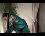 Lucy wearing green rainwear while putting on clean shiny nylon linen (Video)