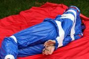 Nicole in an blue sauna suit tied and gagged in the garden (Pics)