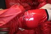 Watching sexy Sandra during her selfbondage action with cuffs in a red shiny nylon Crazy Sensations Chillshorty and a shiny nylon rain jacket in red (www.crazysensations.com). Buy the original Short (used) from us.