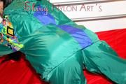 Lucy putting on linen on bed wearing supersexy green shiny nylon rainwear (Pics)
