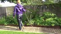 Watching sexy Sandra wearing a sexy blue rain pants and a purple rain jacket watering the flowers in the garden (Video)