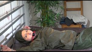 Mara wearing a supersexy green rainwear suit tied and gagged on bed with cuffs and ballgag (Video)