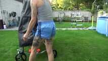 Watch Maly in her shiny nylon Shorts enjoying the warm Weather in the Garden