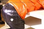 Mara tied and gagged on a table wearing a sexy black down pants and an orange down jacket (Pics)