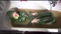Mara wearing a sexy green shiny pvc jumpsuit with hood ties and gagges herself in a bath tub full of mud (Video)